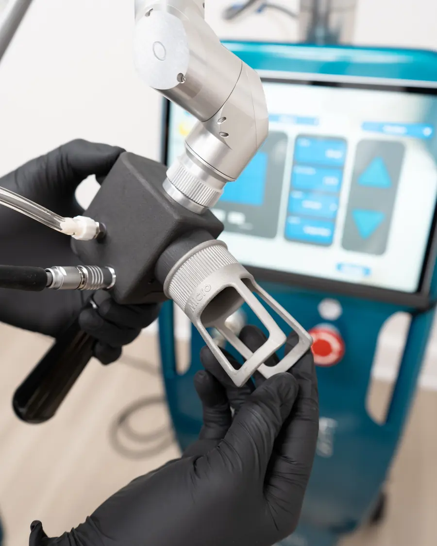 A gloved hand holding the Selene handpiece at the console